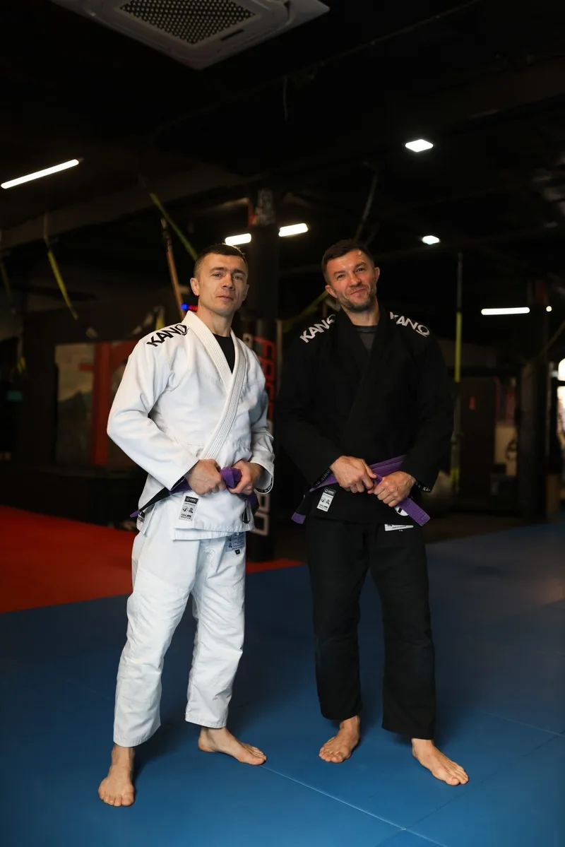 Двое взрослых спортсменов BJJ в ги на тренировке